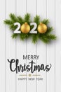 Christmas greeting card. 2020 New Year sign with realistic pine branches and glitter balls on a white wooden background. Royalty Free Stock Photo