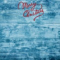 Christmas greeting card on old azure wood background. Merry Christmas inscription. Top view