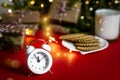 Christmas greeting card on a red background, attributes of the holiday: clock gifts and milk with cookies for santa claus, place Royalty Free Stock Photo