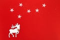 Christmas greeting card with white deer in fir tree forest on red background. Star on sky. Winter Holiday concept Royalty Free Stock Photo