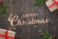 Christmas greeting text hand carved on dark wooden surface with Christmas decorations Royalty Free Stock Photo