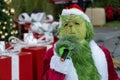 Christmas grinch in a costume singing with a mic