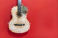 Christmas guitar on a red background in snowflakes. An invitation to a New Year's musical concert. Winter concert on Royalty Free Stock Photo