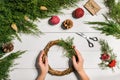 Christmas handmade diy background. Making craft xmas wreath and ornaments. Top view of white wooden table with female Royalty Free Stock Photo