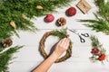 Christmas handmade diy background. Making craft xmas wreath and ornaments. Top view of white wooden table with female Royalty Free Stock Photo