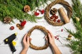 Christmas handmade diy background. Making craft xmas wreath and ornaments. Top view of white wooden table with female Royalty Free Stock Photo