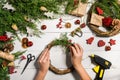 Christmas handmade diy background. Making craft xmas wreath and ornaments. Top view of white wooden table with female Royalty Free Stock Photo