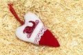 Christmas handmade embroidered decorations soft toys on the straw tinsel background top view shape of hear, the sled