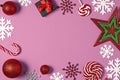 Christmas handmade gift boxes decorated with candy, star, white snowflakes on pink background top view. Royalty Free Stock Photo