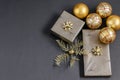 Christmas handmade gift boxes festively wrapped and fortuna gold colored balls and baubles on the black. Care packaged handmade Royalty Free Stock Photo