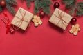 Christmas handmade gift boxes, wooden diy decor, evergreen branches, gingerbread cookies on red. View from above, flat lay. Xmas