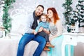 Christmas happy family of three persons and fir tree with gift boxes over white bedroom background Royalty Free Stock Photo