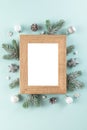 Christmas or Happy New Year blank photo frame with fir tree branches, holiday decorations on blue background Royalty Free Stock Photo