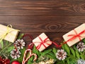 Christmas and Happy New Year dark brown background. Gift Christmas box, fir branches, wooden table, top view, copy space Royalty Free Stock Photo