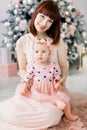 Christmas and Happy New Year Holidays. Family, mother and child concept. Happy mom and her cute baby girl in pink Royalty Free Stock Photo