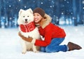 Christmas happy smiling woman having fun with white Samoyed dog on snow in winter day Royalty Free Stock Photo