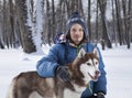 Christmas happy teenager boy playing with white Husky dog in winter day, dog and child on snow Royalty Free Stock Photo