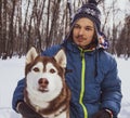 Christmas happy teenager boy playing with white Husky dog in winter day, dog and child on snow Royalty Free Stock Photo