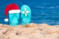 Christmas hat on flip flops in the sand of a beach Royalty Free Stock Photo