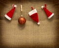 Christmas hats hanging on brown cloth background. Royalty Free Stock Photo