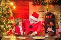 Christmas helper child writing letter to Santa Claus letter in red hat. Cute little boy writing letter to Santa Claus at Royalty Free Stock Photo