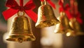 Gold bells adorned with red ribbons, likely used as festive decorations, hang in a row. Royalty Free Stock Photo