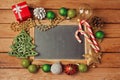 Christmas holiday background with blank chalkboard on wooden table and Christmas decorations.