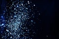 Christmas and holiday background. Blue glowing abstract glitter on black Royalty Free Stock Photo