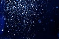 Christmas and holiday background. Blue glowing abstract glitter on black Royalty Free Stock Photo