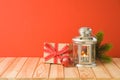 Christmas holiday background with candle lantern and gift box on wooden table Royalty Free Stock Photo
