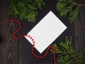 Christmas holiday background with copy space for text. Flat lay, top view. Decorative frame of fir branches and red beads. Paper Royalty Free Stock Photo