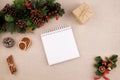 Christmas holiday background with diary and fir tree decorated with pine cone, cinnamon sticks and gift wrapped in kraft paper, Royalty Free Stock Photo
