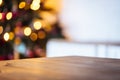 Christmas holiday background with empty rustic table and the bokeh of the living room with the Christmas tree