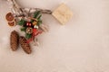 Christmas holiday background with fir tree decorated with pine cone, cinnamon sticks and gift wrapped in kraft paper, dried Royalty Free Stock Photo