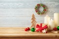 Christmas holiday background with gift box, ornaments and candle decor on wooden table. Winter greeting card Royalty Free Stock Photo