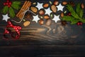 Christmas holiday background with gingerbread cookies, spices and fir branches on the old wooden board. Copy space Royalty Free Stock Photo