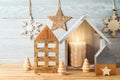 Christmas holiday background with home decor house and candle on wooden table. Winter greeting card