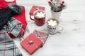 Christmas holiday background with hot cocoa, gift boxes and women`s winter clothing