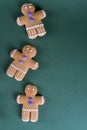 Christmas and holiday baking . Ginger men cookies with decor on green. Recipe green background. Royalty Free Stock Photo