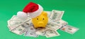 Christmas holiday bonus and expenses. Piggy bank with Santa hat on US dollars money