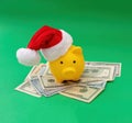 Christmas holiday bonus and expenses. Piggy bank with Santa hat on US dollars money