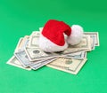 Christmas holiday bonus and expenses. Santa hat on US dollars money