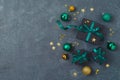 Christmas holiday concept with black gift boxes, green ribbons and decorations on dark background. Top view, flat lay