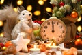 Christmas or holiday decoration background - small fir tree, retro alarm clock shows midnight and sweet food. New year still life