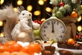 Christmas or holiday decoration background - small fir tree, retro alarm clock shows midnight and sweet food. New year still life