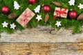 Christmas decoration with gifts, red balls, fir green frame and ornaments on wood background Royalty Free Stock Photo