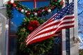 Christmas Decorations in a Window and an American Flag Royalty Free Stock Photo