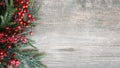 Holiday Evergreen Branches and Berries Over Rustic Wood Background Royalty Free Stock Photo