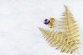 Christmas holiday festive theme with golden violet Christmas ornament and gold decorative fern leaves