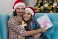 Christmas Holiday Happy Couple Wear New Year Santa Hat Cap, Man And Woman Embracing Holding Present Box Royalty Free Stock Photo